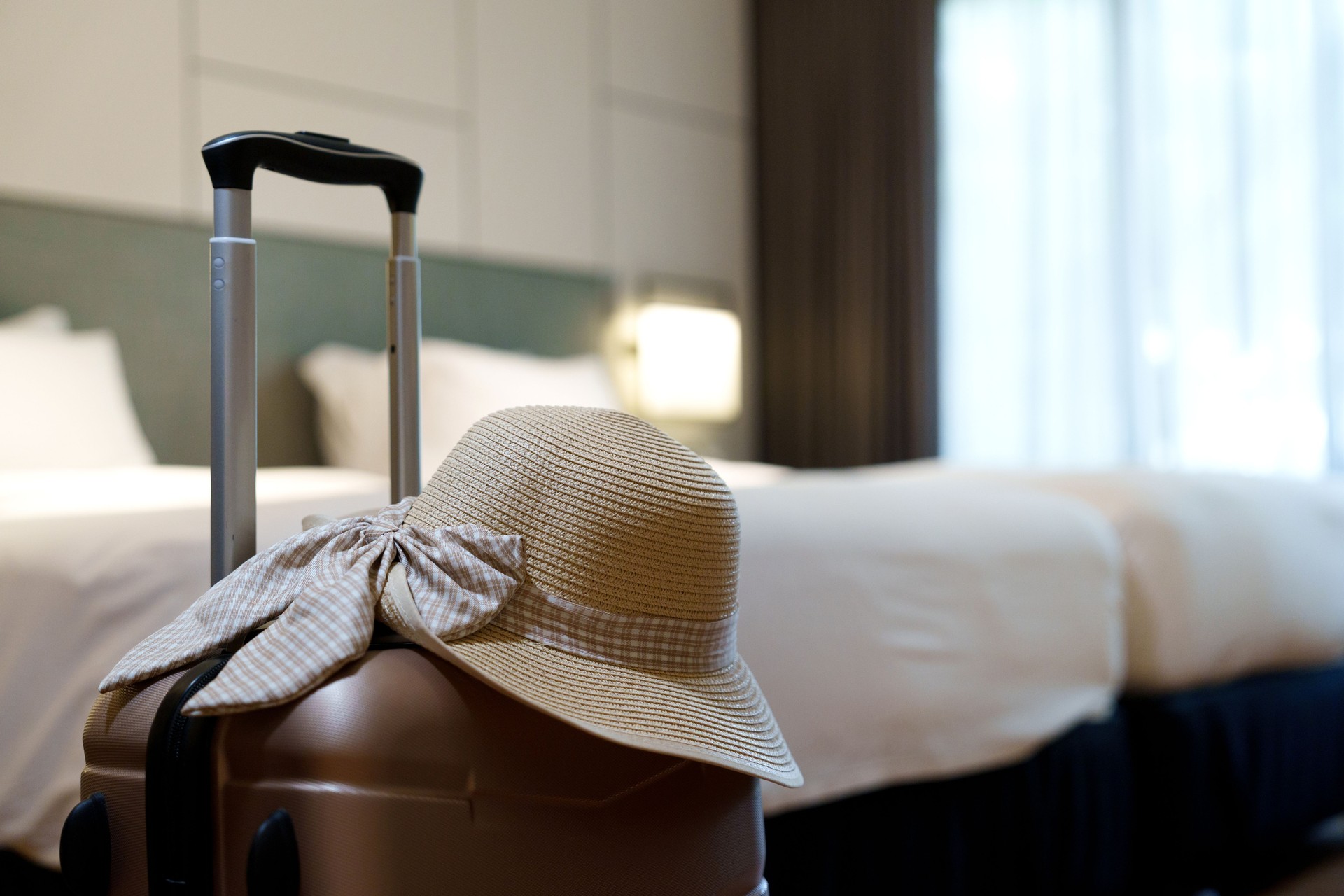 Travel Suitcase with Sun Hat in a Hotel Room